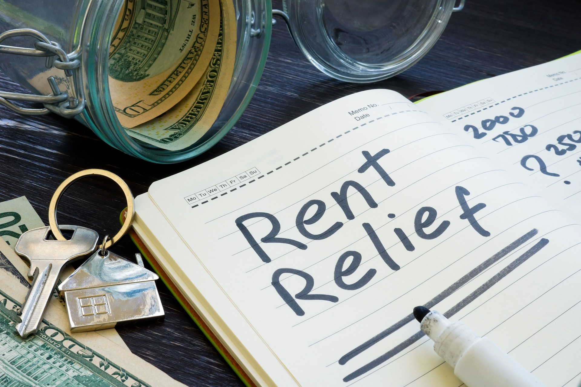 Rent relief sign and almost empty jar with money.